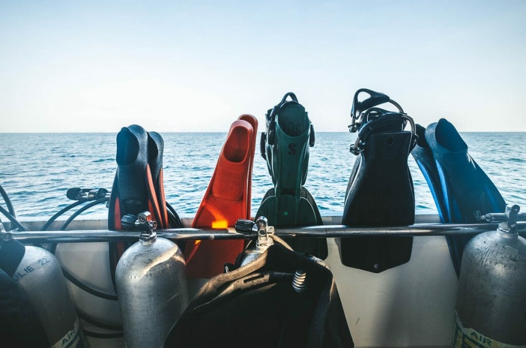 Various scuba fins on a railing
