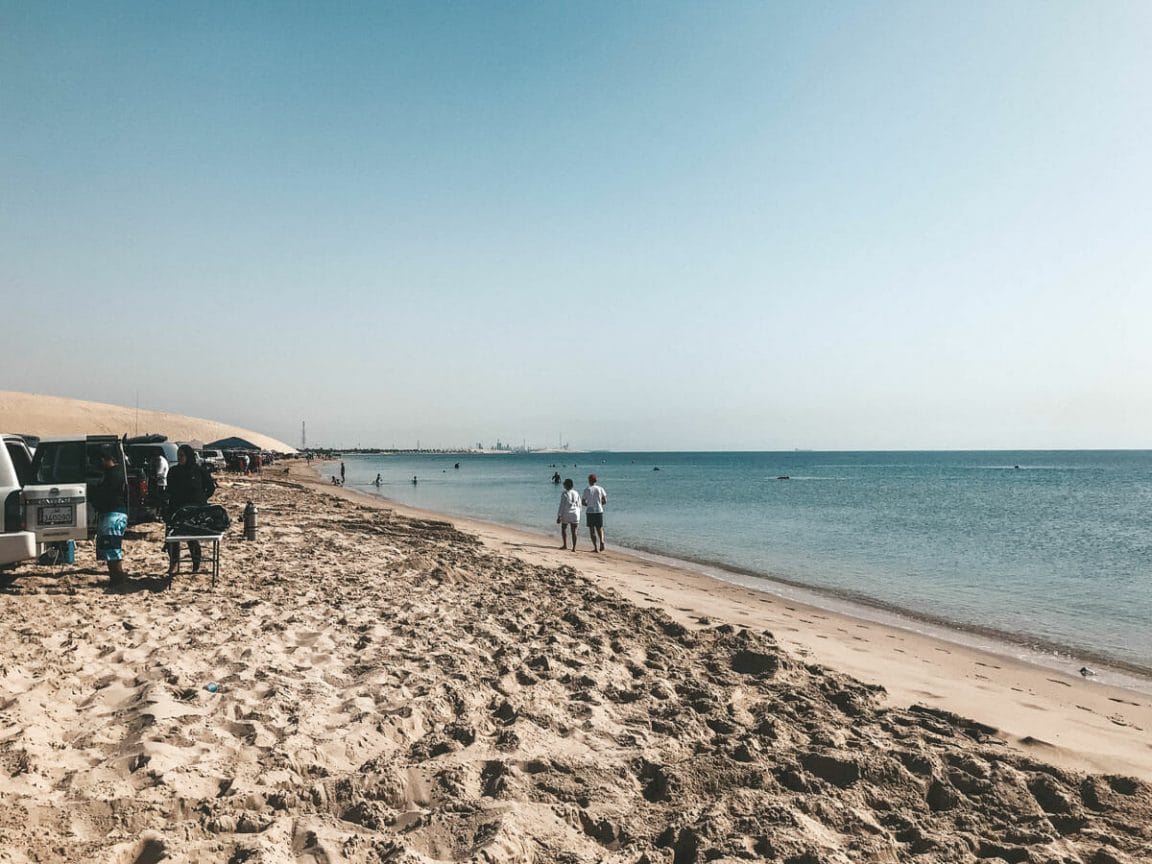 View of Doha from Sealine beach and divers in the water