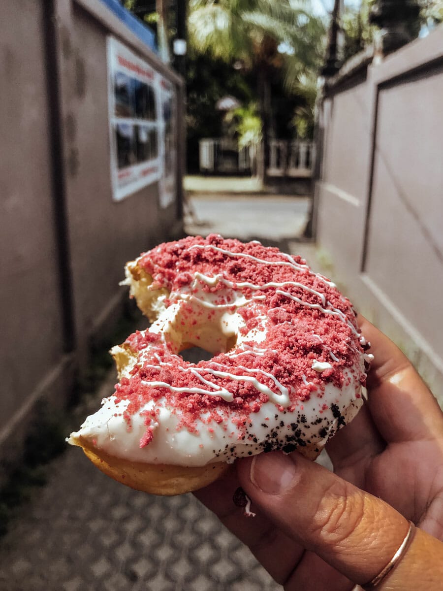 Hand holding half eating donut