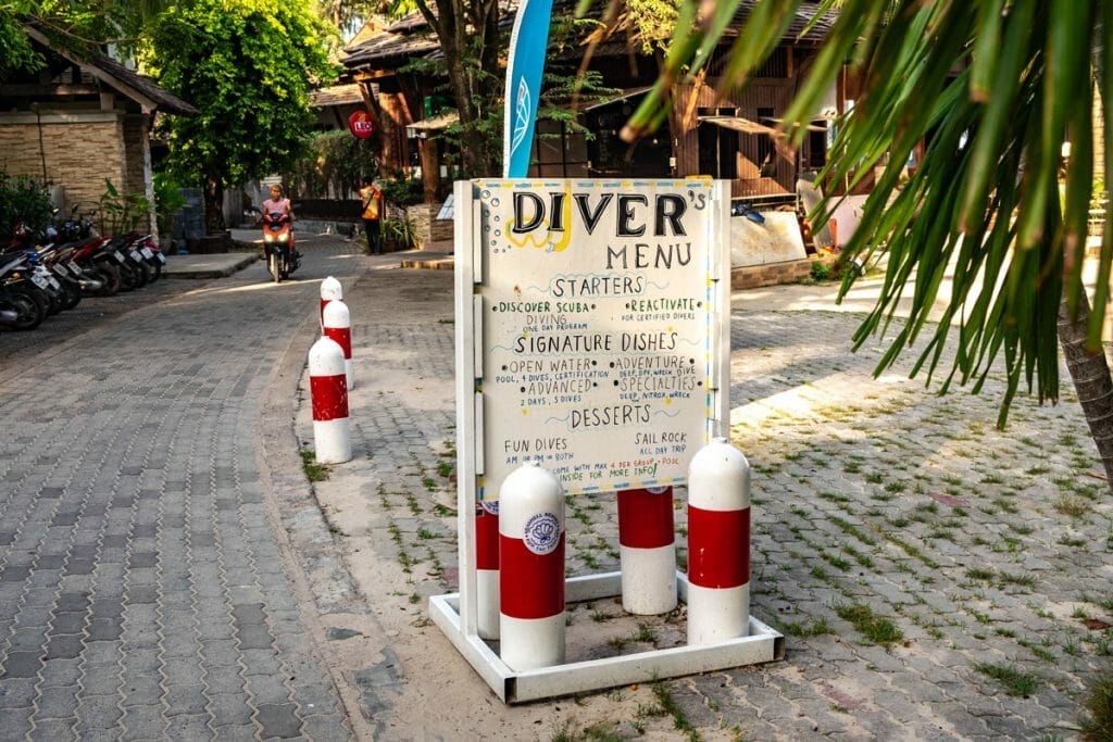 Sign for a dive school with red and white painted tanks