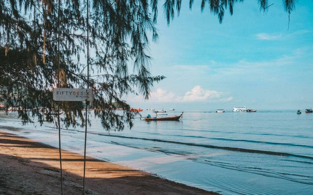 Longtail boat and sign on Sairee beach for a dive school