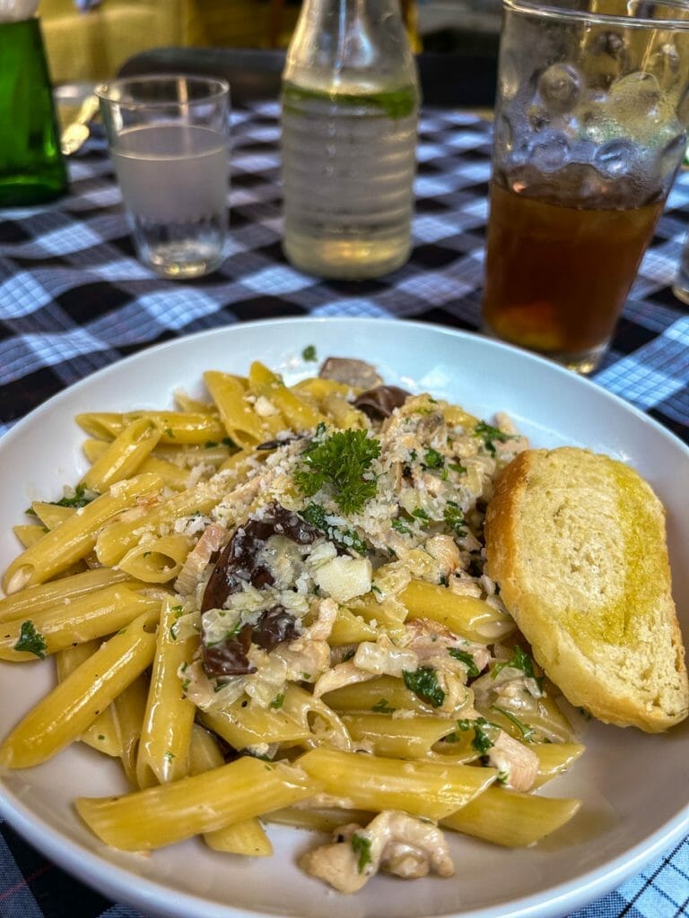 Plate with penne pasta and slice of bread